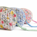 Quilted cosmetic case featuring a vintage-inspired floral print with soft padding and a structured shape, designed for storing makeup and small essentials.
