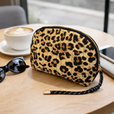 Quilted cosmetic case with a vintage-inspired leopard print design, featuring a soft padded texture and zip closure for stylish and functional storage.