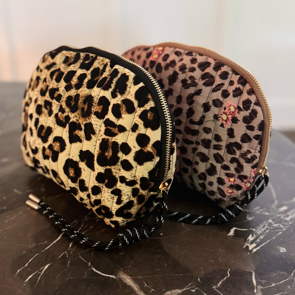 Quilted cosmetic case with a vintage-inspired leopard print design, featuring a soft padded texture and zip closure for stylish and functional storage.