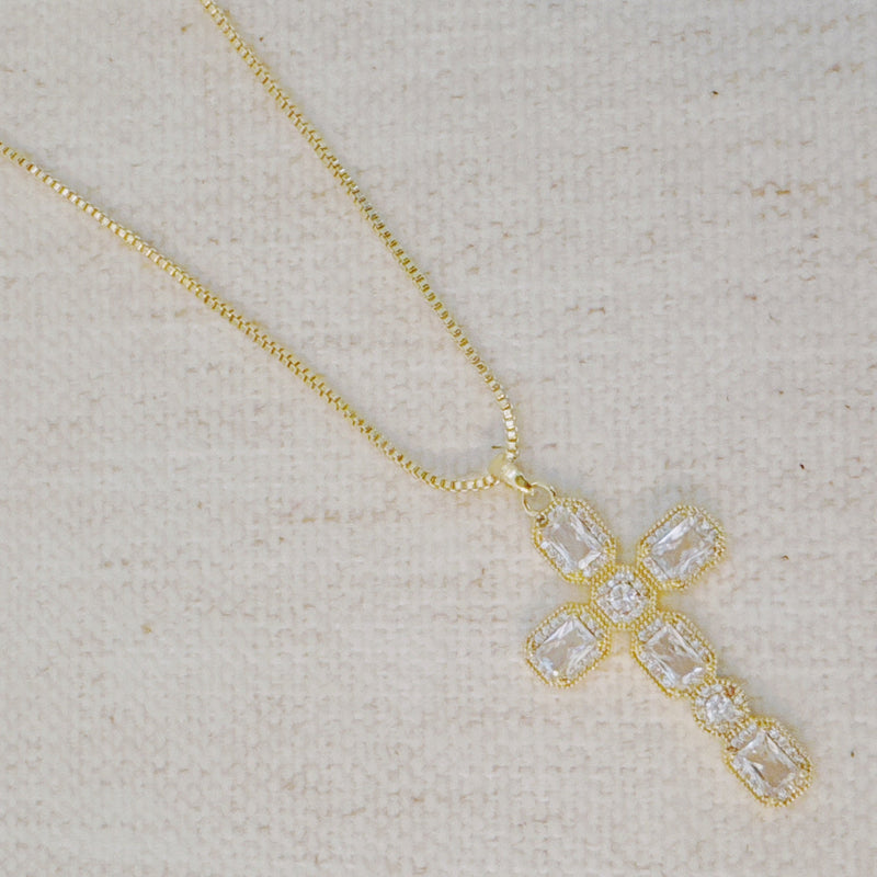 Gold-tone necklace featuring a vintage-inspired cross pendant adorned with sparkling crystals for a timeless and elegant look.