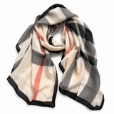 A lightweight scarf with a classic check pattern in beige, gray, black, and coral pink, draped on a clean white background.