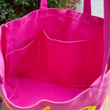 Pink tote bag with a pocket on a blurred natural background