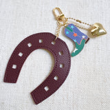 Purple horseshoe bag charm with a colorful boot and golden star – lucky western theme