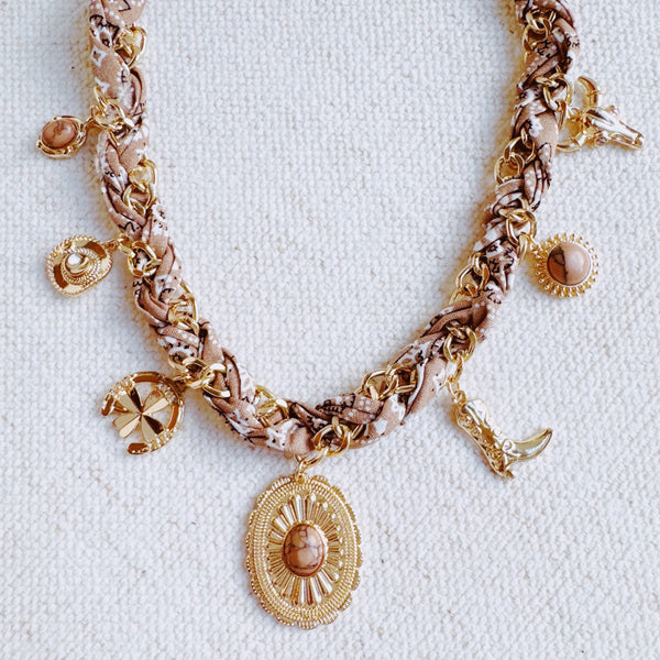 Chain necklace woven with printed scarf fabric, adorned with Western-themed charms including a boot, sunburst, and sheriff star.