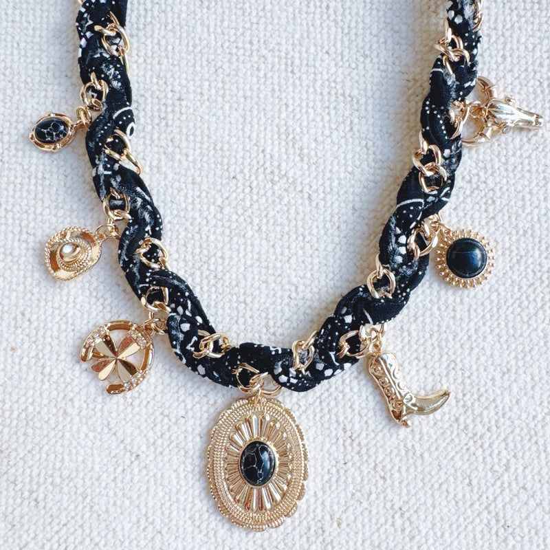 Chain necklace woven with printed scarf fabric, adorned with Western-themed charms including a boot, sunburst, and sheriff star.