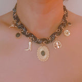 Chain necklace woven with printed scarf fabric, adorned with Western-themed charms including a boot, sunburst, and sheriff star.