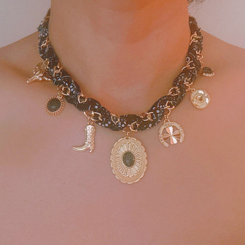 Chain necklace woven with printed scarf fabric, adorned with Western-themed charms including a boot, sunburst, and sheriff star.