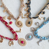 Chain necklace woven with printed scarf fabric, adorned with Western-themed charms including a boot, sunburst, and sheriff star.