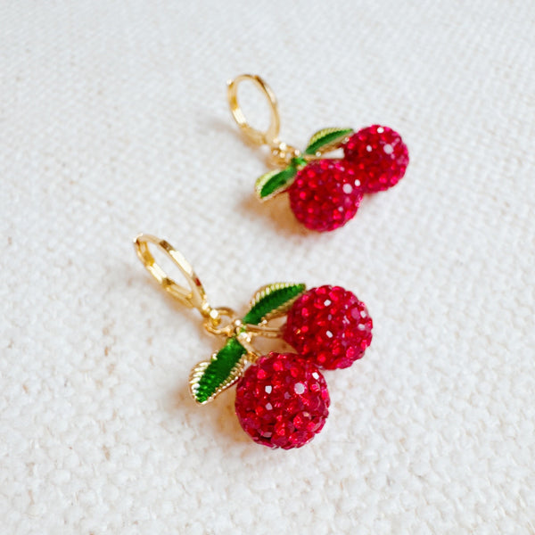  Playful gold-tone huggie earrings featuring dangling red cherry charms—adding a sweet and fruity pop to any look.