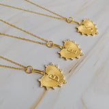 A collection of gold-plated heart-shaped initial necklaces displayed on a surface.