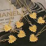 A collection of gold-plated heart-shaped initial necklaces displayed on a surface.