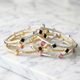 Set of three bracelets with floral designs on a marble surface