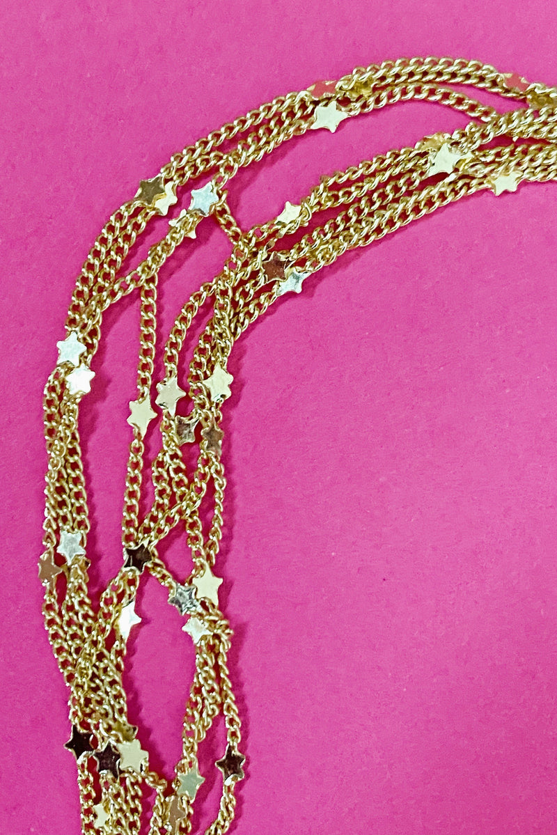 close up gold chain necklace with tiny star charms 
