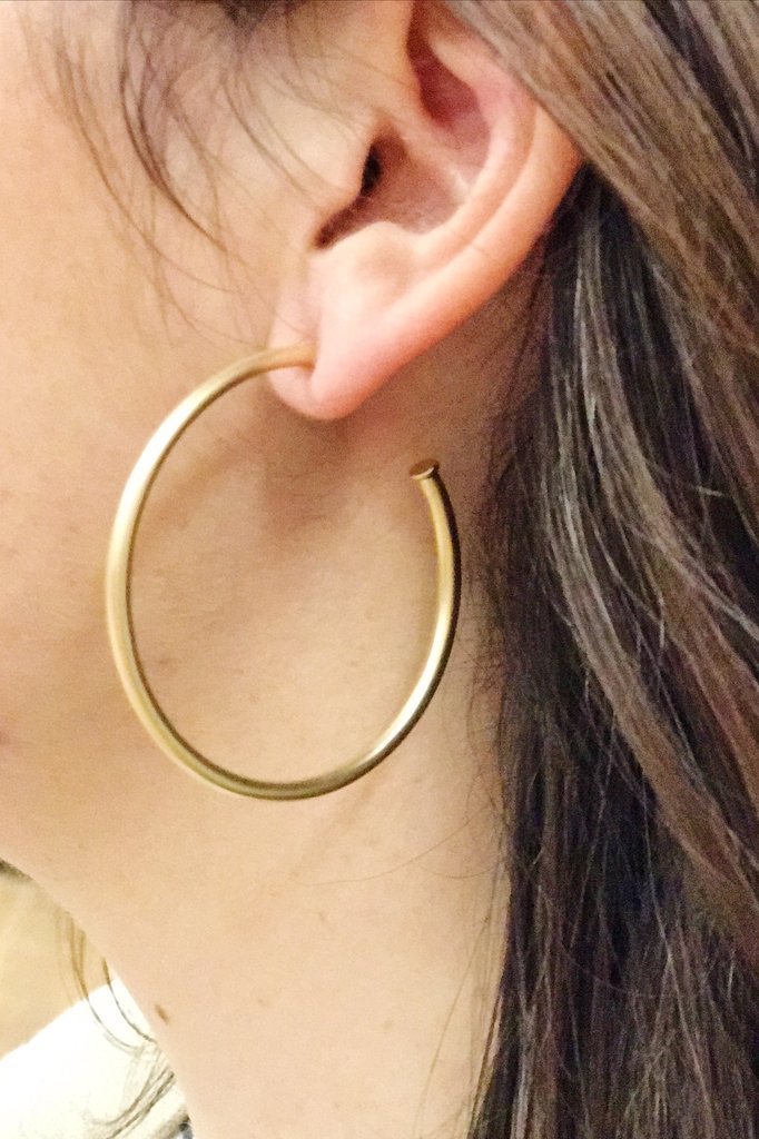 Woman wearing matte gold hoop earrings from online Jewelry Boutique Ellison + Young