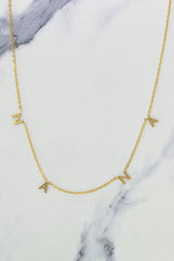 Gold chain necklace featuring spaced letter charms that spell “NANA” in a polished gold finish, designed as a meaningful everyday or giftable piece.